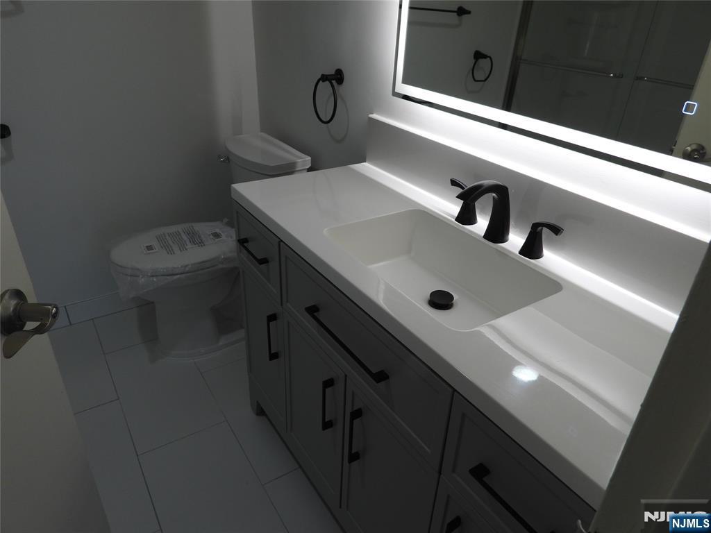 55 Clinton Place, Unit 301 Hackensack, NJ 07601 - Photo 16 of 17 a bathroom with a sink a toilet and shower