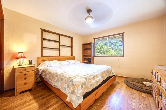 a bedroom with a bed and wooden floor