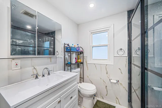a bathroom with a sink vanity granite and toilet