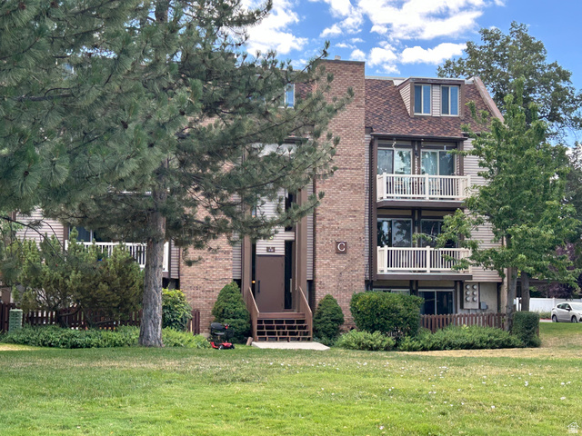88 West 50 South, Unit C1 Centerville, UT 84014 - Photo 1 of 16 Multi-story residential building featuring brick and siding facade, private balconies with white railings, and a prominent dormer window