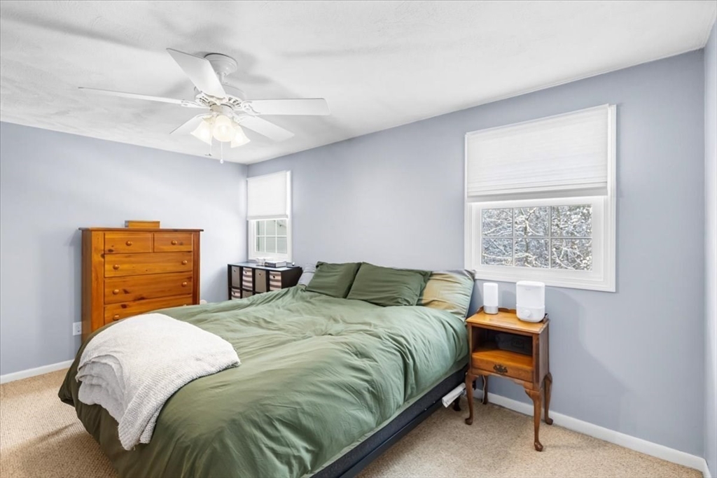 104 Newcomb Street, Unit E Norton, MA 02766 - Photo 7 of 21 a bedroom with a bed and a chandelier