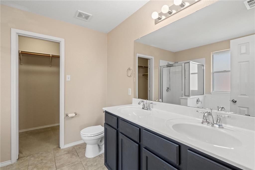 20224 Merlin Falcon Trail Pflugerville, TX 78660 - Photo 10 of 40 Double vanity and a walk-in closet highlight this clean and functional primary bathroom.