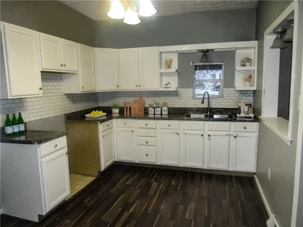 a kitchen with granite countertop white cabinets and white appliances