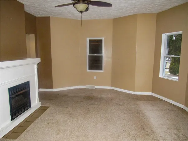 a view of an empty room with a fireplace