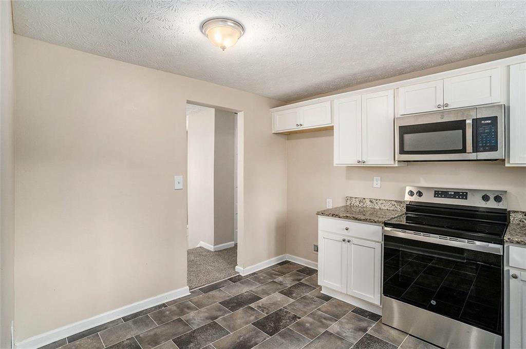 2039 Raintree Place Lithonia, GA 30058 - Photo 16 of 18 a kitchen with stainless steel appliances a stove microwave and sink