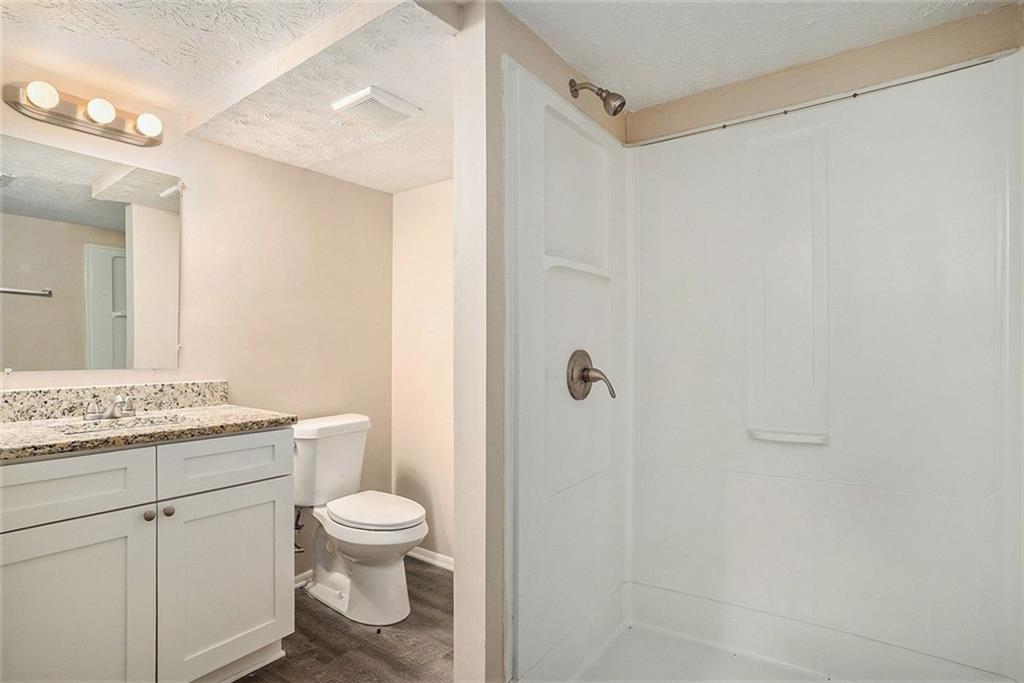 2039 Raintree Place Lithonia, GA 30058 - Photo 6 of 18 a bathroom with a granite countertop sink a toilet and a mirror