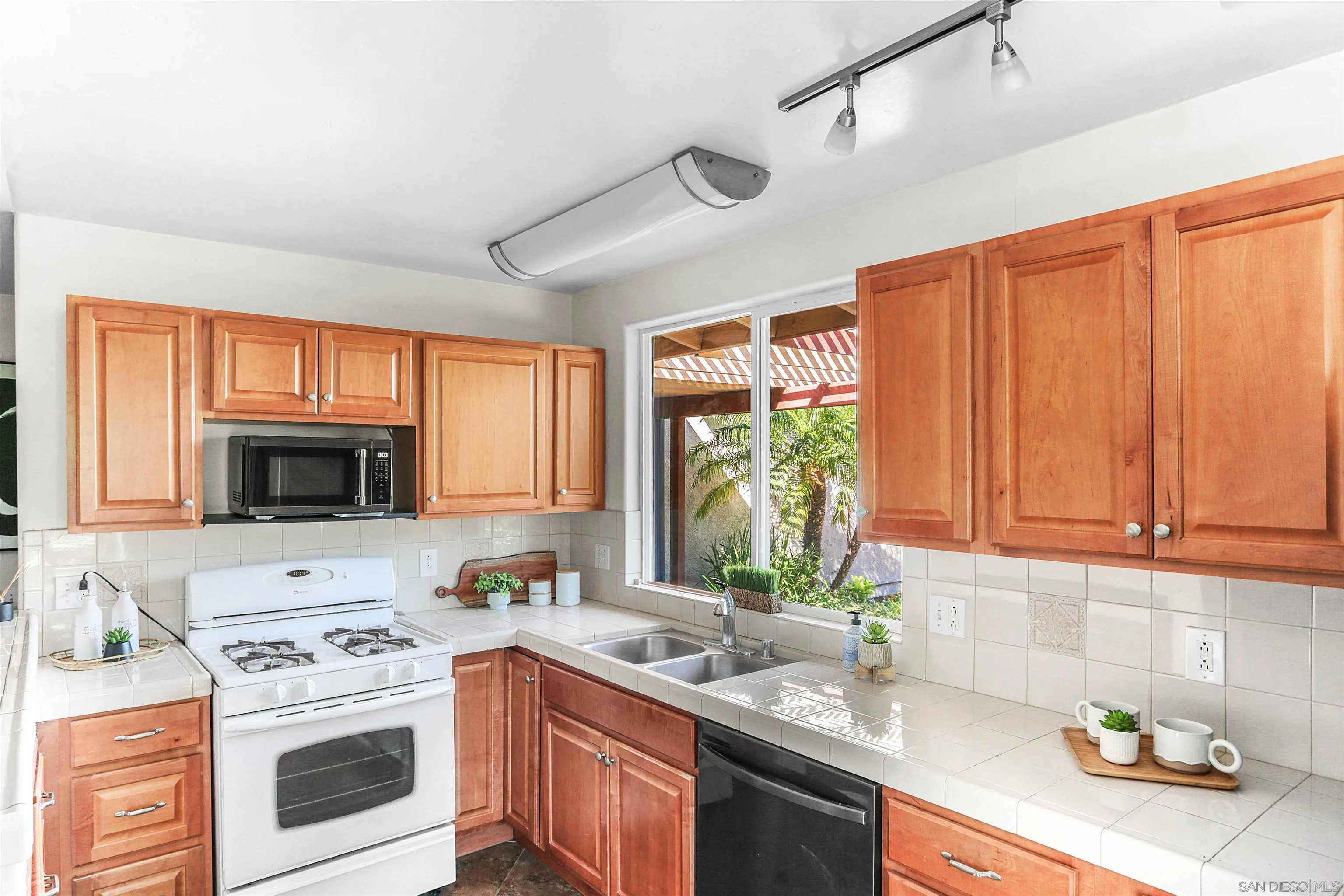 14287 Lolin Lane Poway, CA 92064 - Photo 12 of 35 a kitchen with stainless steel appliances granite countertop a stove a sink dishwasher and a microwave oven with large cabinets