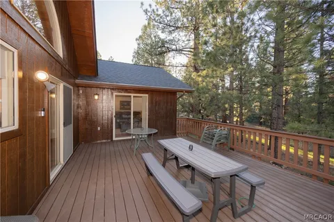 a balcony with wooden floor table and chairs