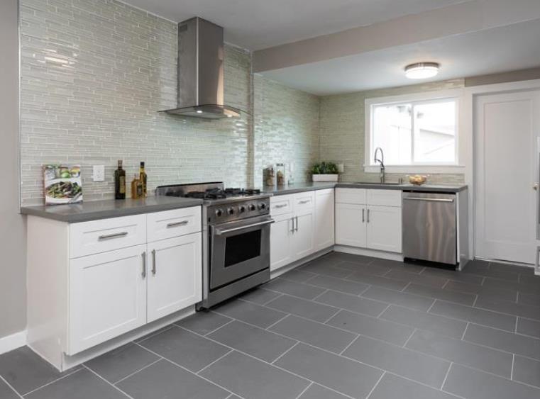 1557 79th Avenue Oakland, CA 94621 - Photo 2 of 11 a kitchen with stainless steel appliances a stove a sink and white cabinets