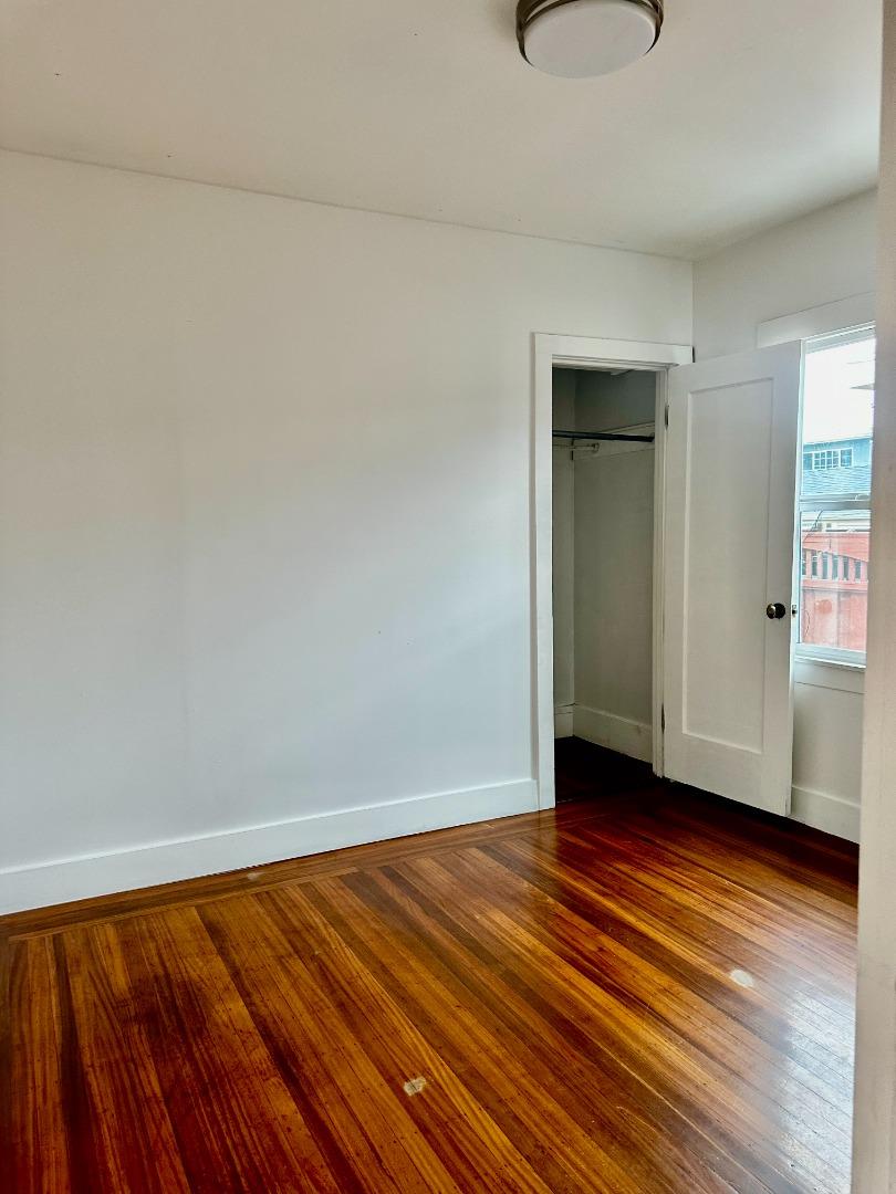 1557 79th Avenue Oakland, CA 94621 - Photo 7 of 11 a view of an empty room with wooden floor and a window