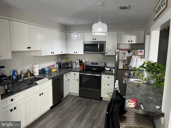 a kitchen with stainless steel appliances granite countertop a sink dishwasher stove refrigerator and cabinets