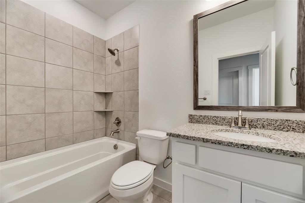 208 Venice Avenue Flower Mound, TX 75028 - Photo 14 of 17 a bathroom with a granite countertop sink a toilet and bathtub