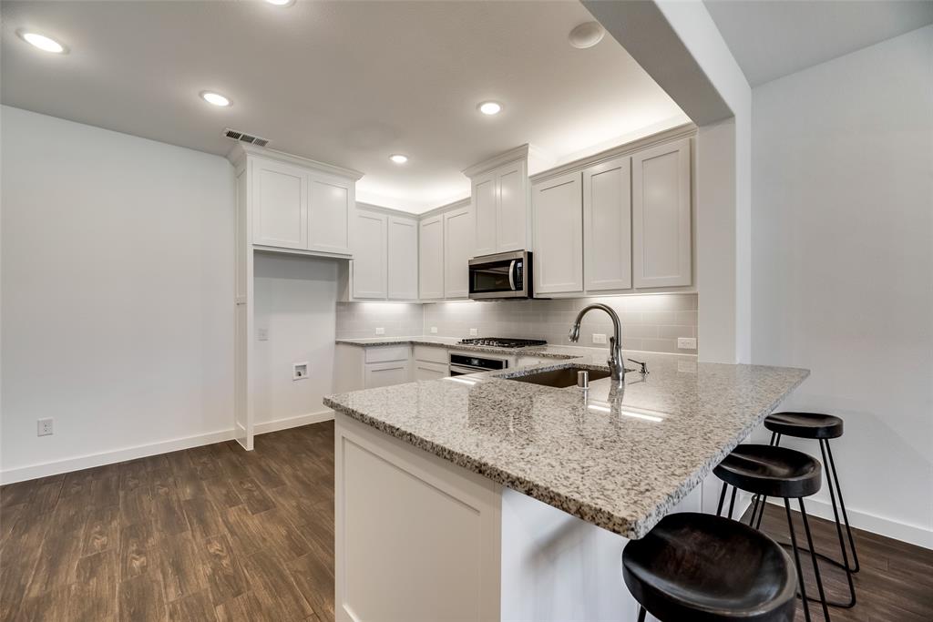 208 Venice Avenue Flower Mound, TX 75028 - Photo 5 of 17 a kitchen with stainless steel appliances granite countertop a sink stove and cabinets