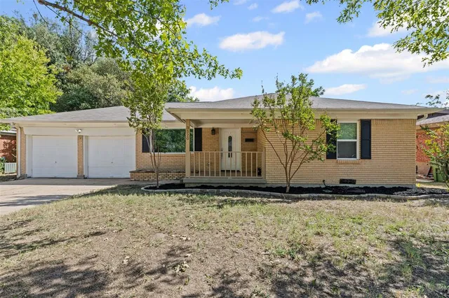 a view of a house with backyard and trees