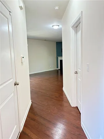an empty room with wooden floor fireplace and windows