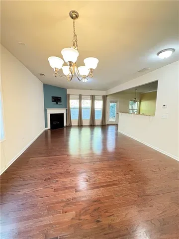 a view of a livingroom with wooden floor and a flat screen tv