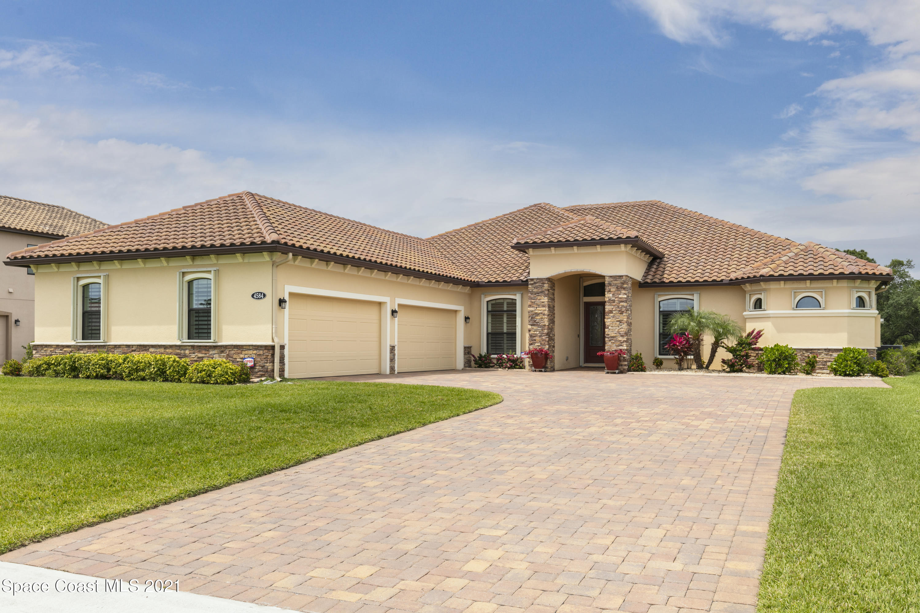 a front view of a house with a garden and yard