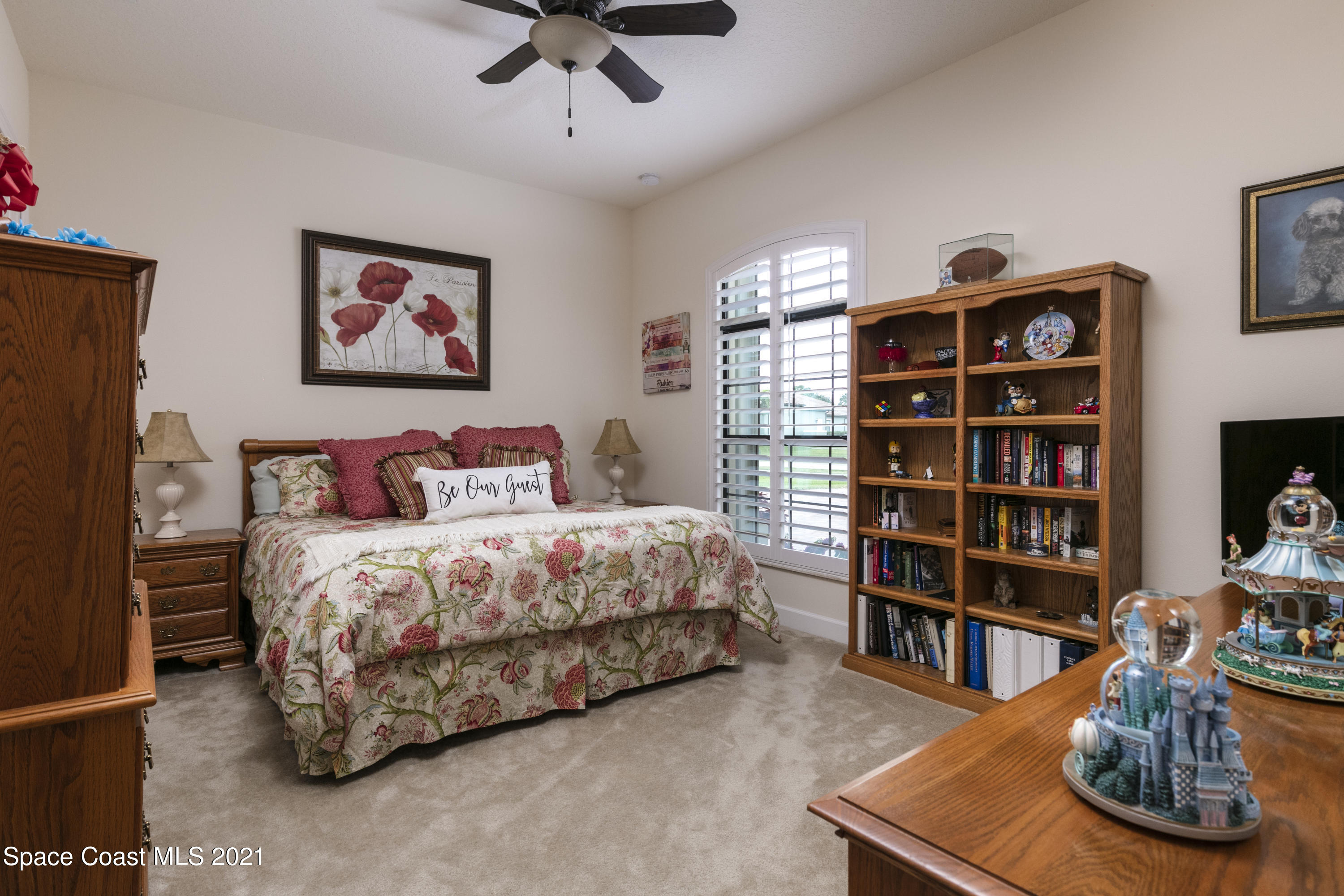 4584 Preservation Circle Melbourne, FL 32934 - Photo 12 of 34 a bedroom with a bed and book shelf