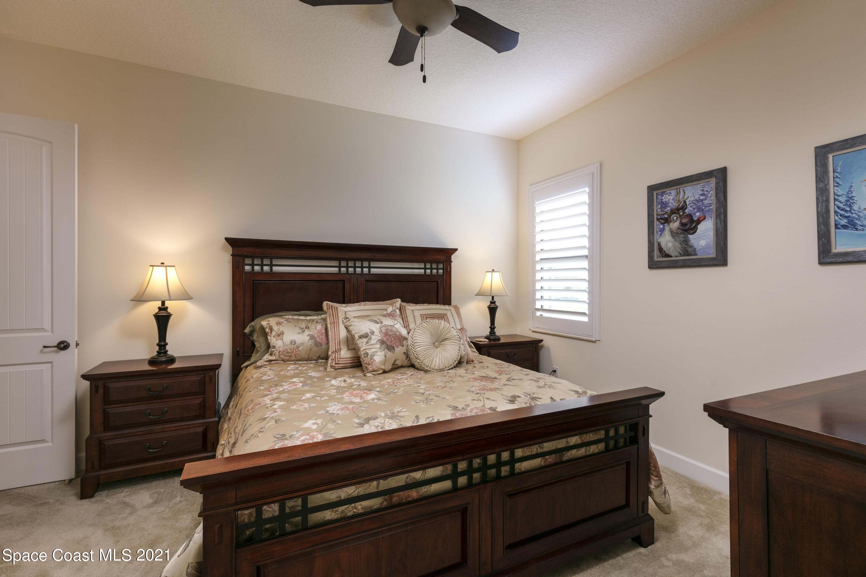 4584 Preservation Circle Melbourne, FL 32934 - Photo 14 of 34 a bedroom with a bed and a potted plant on the dresser