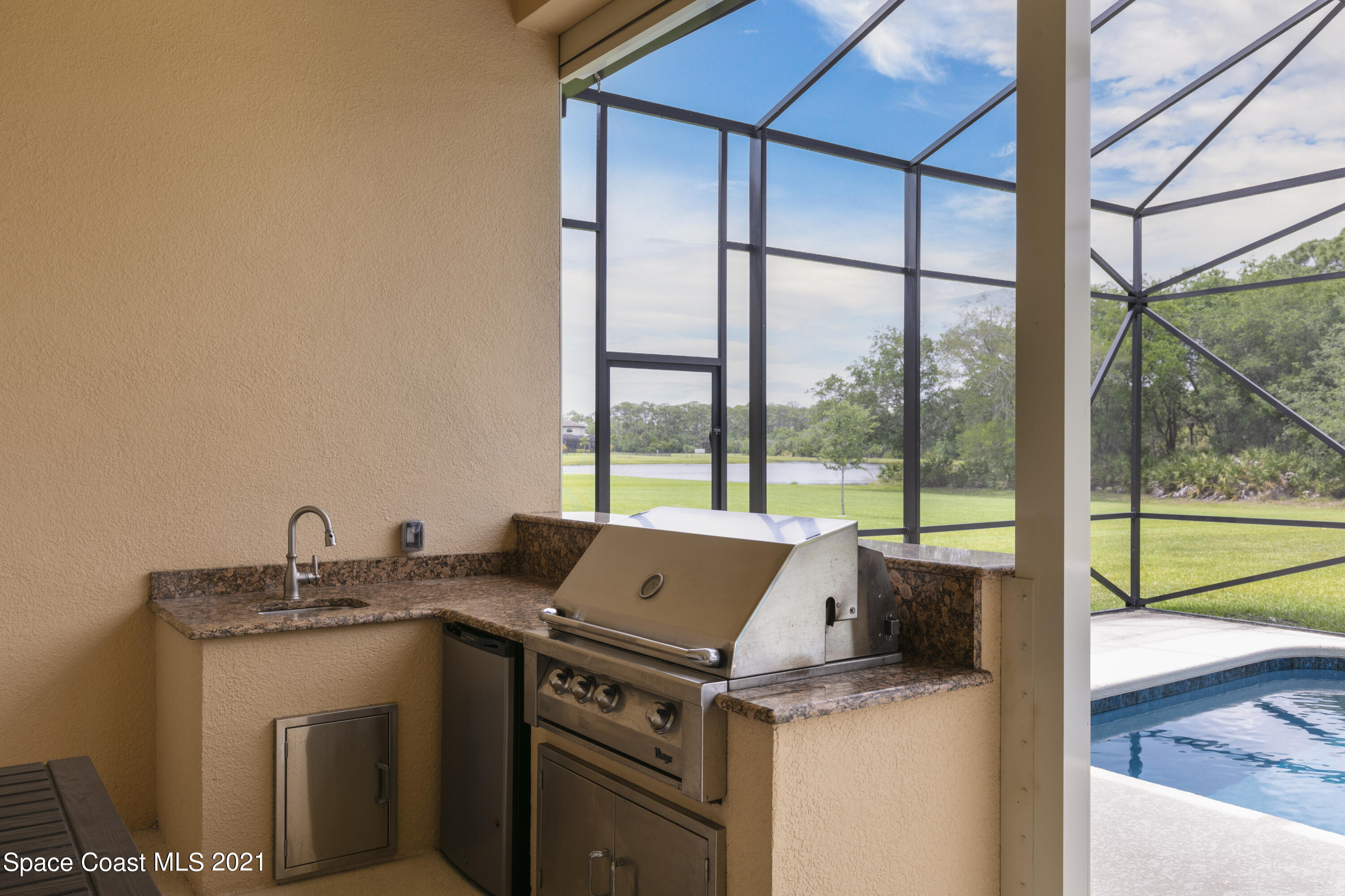 4584 Preservation Circle Melbourne, FL 32934 - Photo 17 of 34 a view of open kitchen with granite countertop a sink and a stove top oven