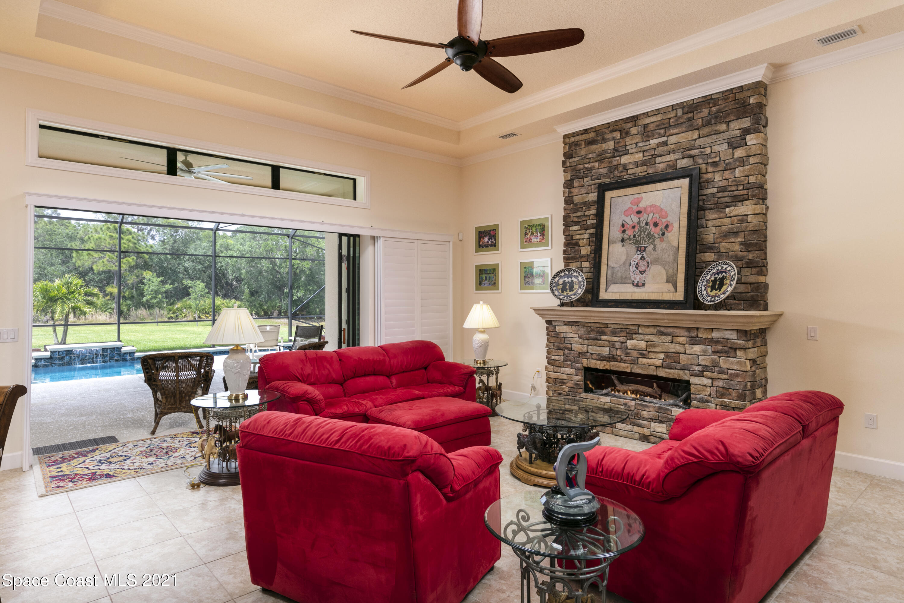 4584 Preservation Circle Melbourne, FL 32934 - Photo 3 of 34 a living room with furniture a flat screen tv and a fireplace
