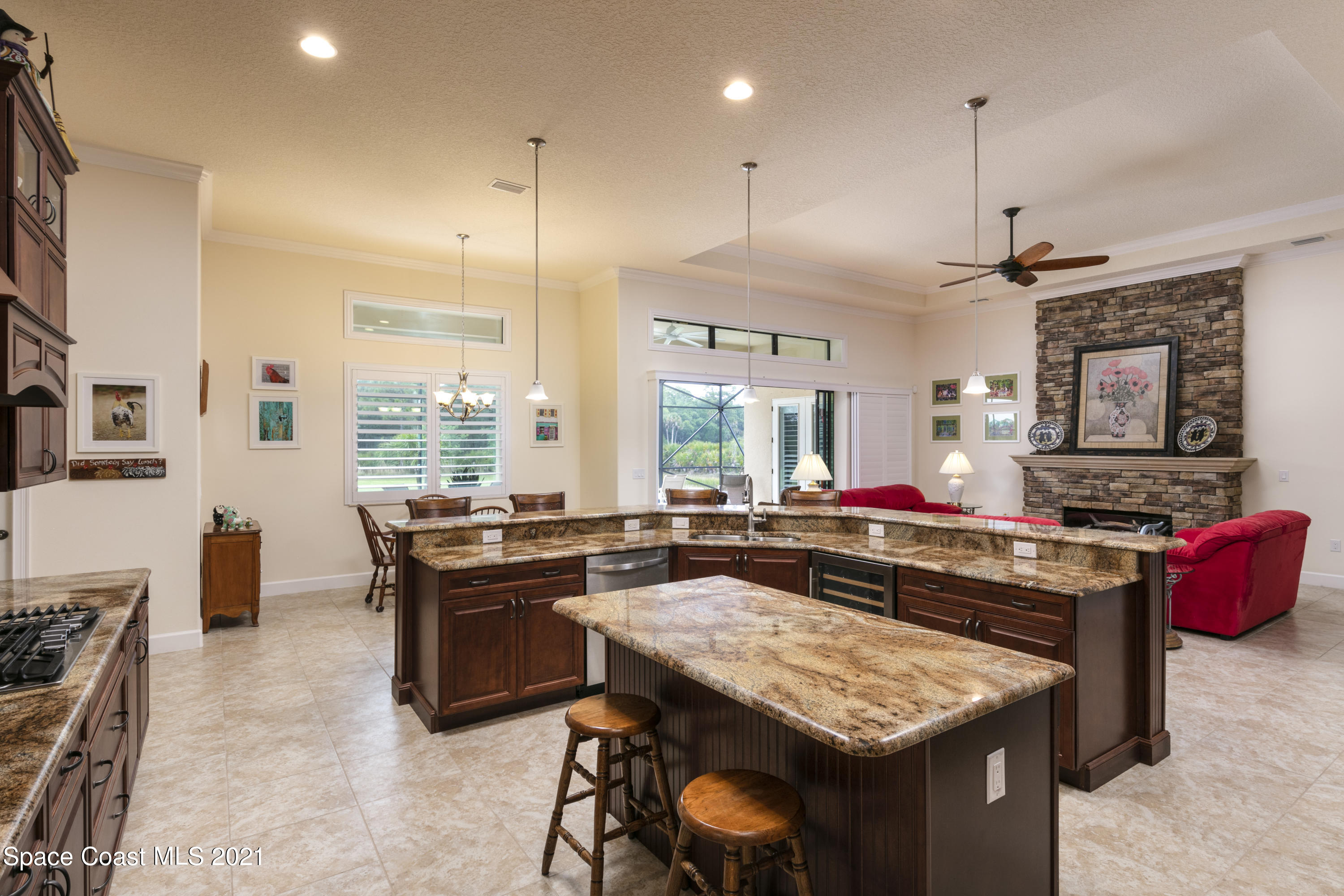 4584 Preservation Circle Melbourne, FL 32934 - Photo 7 of 34 a kitchen with a stove a sink a kitchen island with chairs and wooden floor