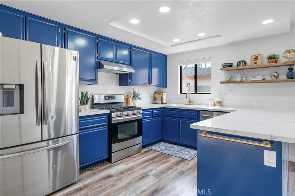 700 West 2nd Street Azusa, CA 91702 - Photo 7 of 75 a kitchen with stainless steel appliances granite countertop a refrigerator stove a sink and dishwasher with wooden floors
