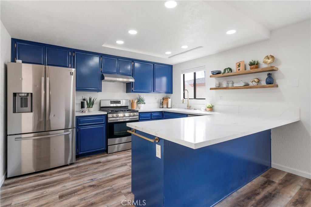 700 West 2nd Street Azusa, CA 91702 - Photo 8 of 75 a kitchen with stainless steel appliances granite countertop a refrigerator a sink dishwasher a stove with wooden floors and cabinets