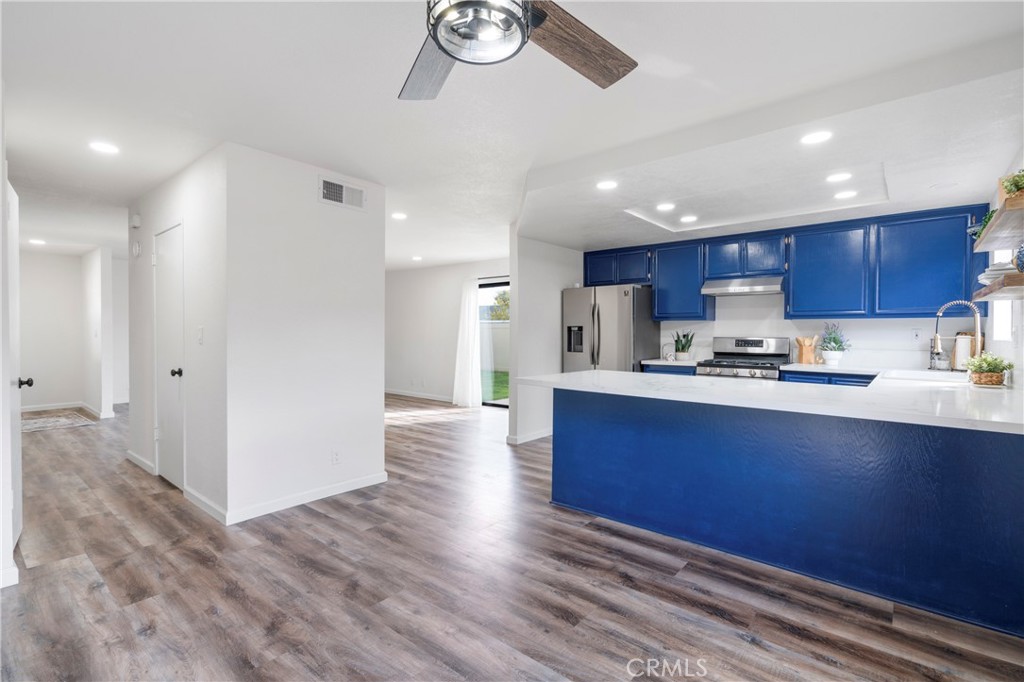 700 West 2nd Street Azusa, CA 91702 - Photo 9 of 75 a kitchen with stainless steel appliances granite countertop a refrigerator a sink dishwasher a stove and white cabinets with wooden floor