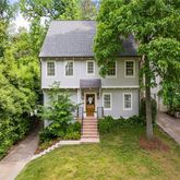 a front view of a house with a yard and trees