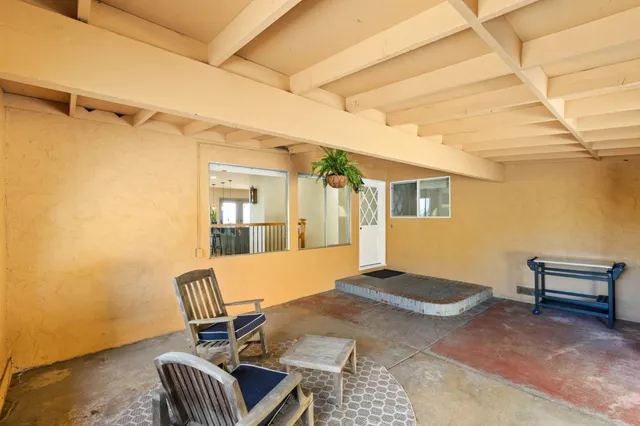 a view of a balcony with wooden floor and iron stairs