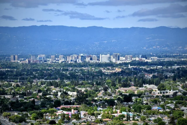 a view of roof deck with table and chairs a barbeque with wooden floor and fence