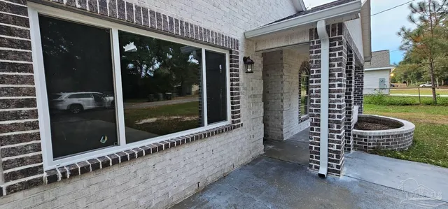 a view of a porch with chairs and potted plants