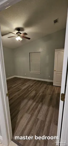 a backyard of a house with large trees and brick walls