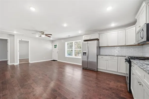a view of a kitchen with wooden floor and windows