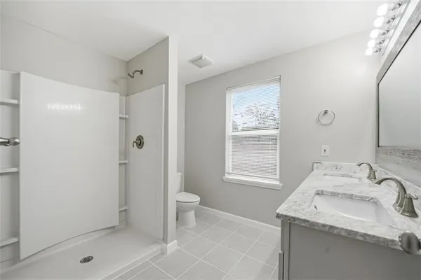 a bathroom with a sink toilet and shower
