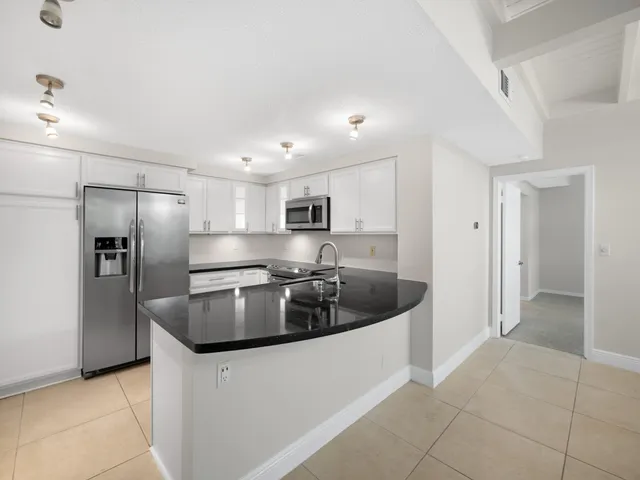 a kitchen with stainless steel appliances granite countertop a sink and a refrigerator
