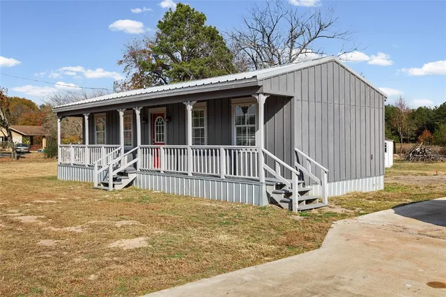 a view of a house with a small yard and wooden fence