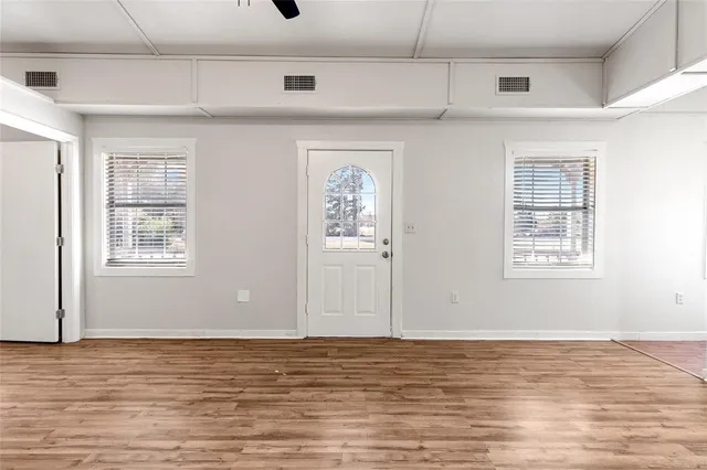 a view of a room with wooden floor and window