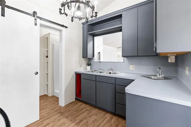 a kitchen with a sink cabinets and wooden floor