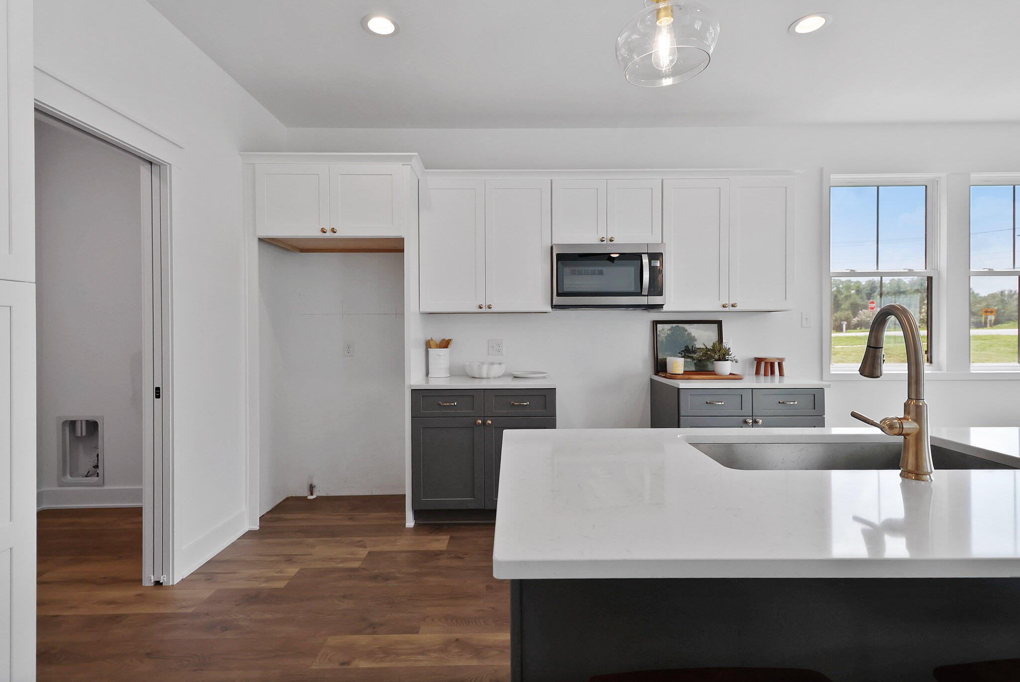 2183 Foley Street Portage, IN 46368 - Photo 11 of 22 a large kitchen with kitchen island a sink dishwasher a stove a refrigerator and white cabinets with wooden floor