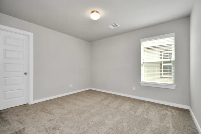 an empty room with closet and windows