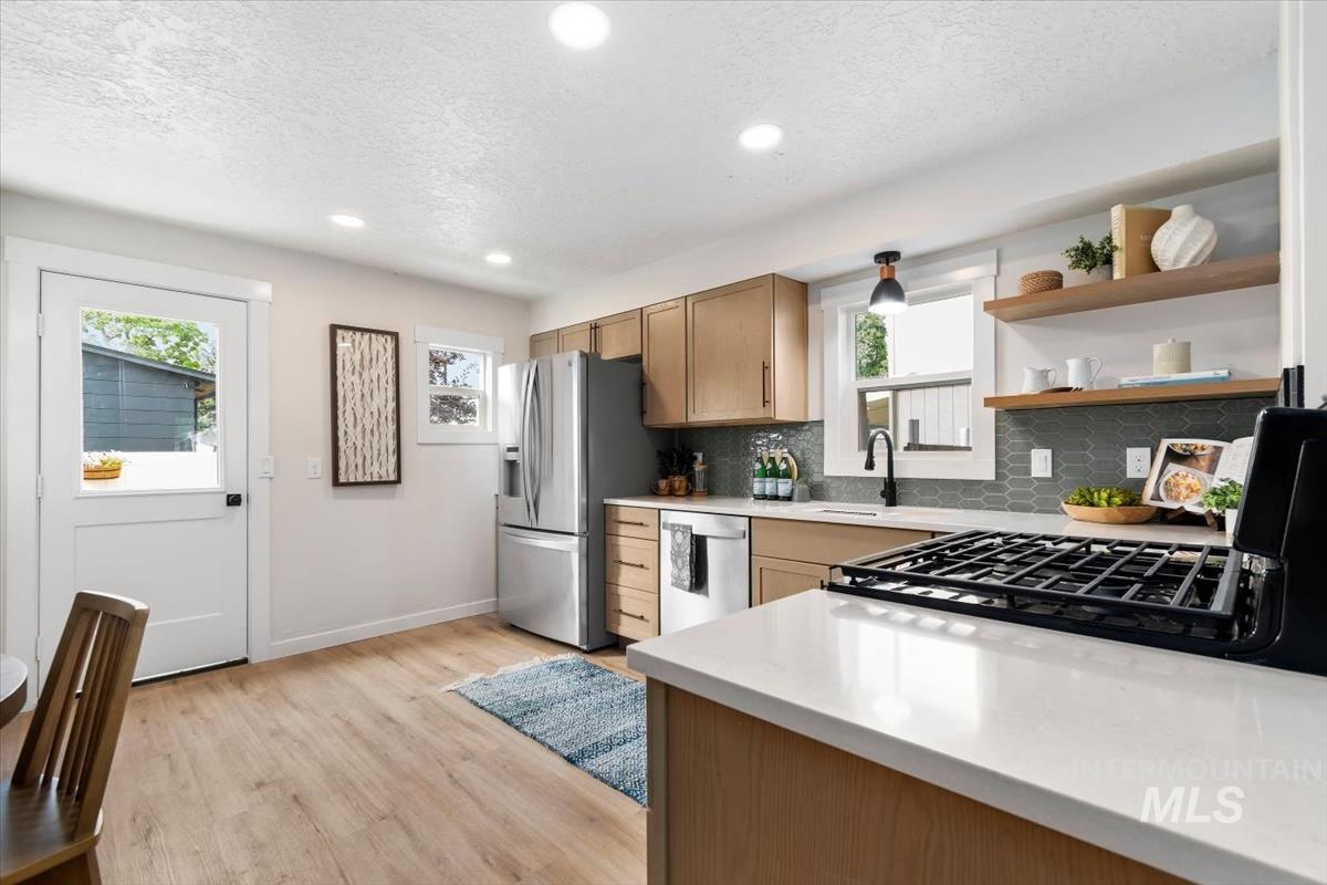 3005 West Hester Street Boise, ID 83702 - Photo 10 of 32 Kitchen featuring light wood-finish flooring, recessed lighting, and a white countertop island with an integrated gas cooktop