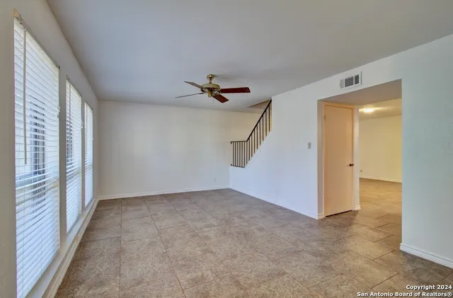 a view of a livingroom with a ceiling fan and window