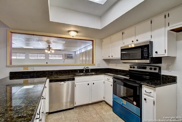 a kitchen with stainless steel appliances a stove sink and cabinets