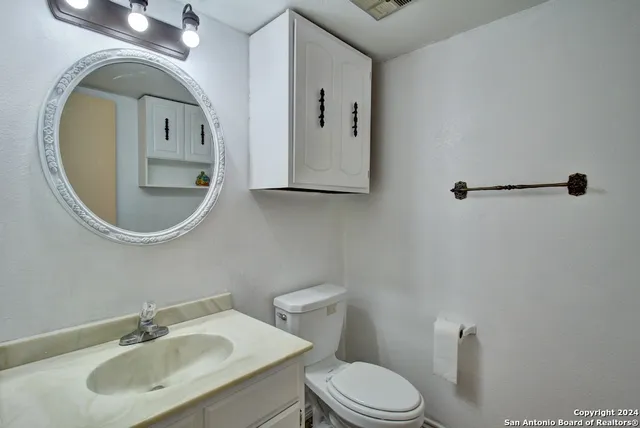 a bathroom with a toilet sink and mirror