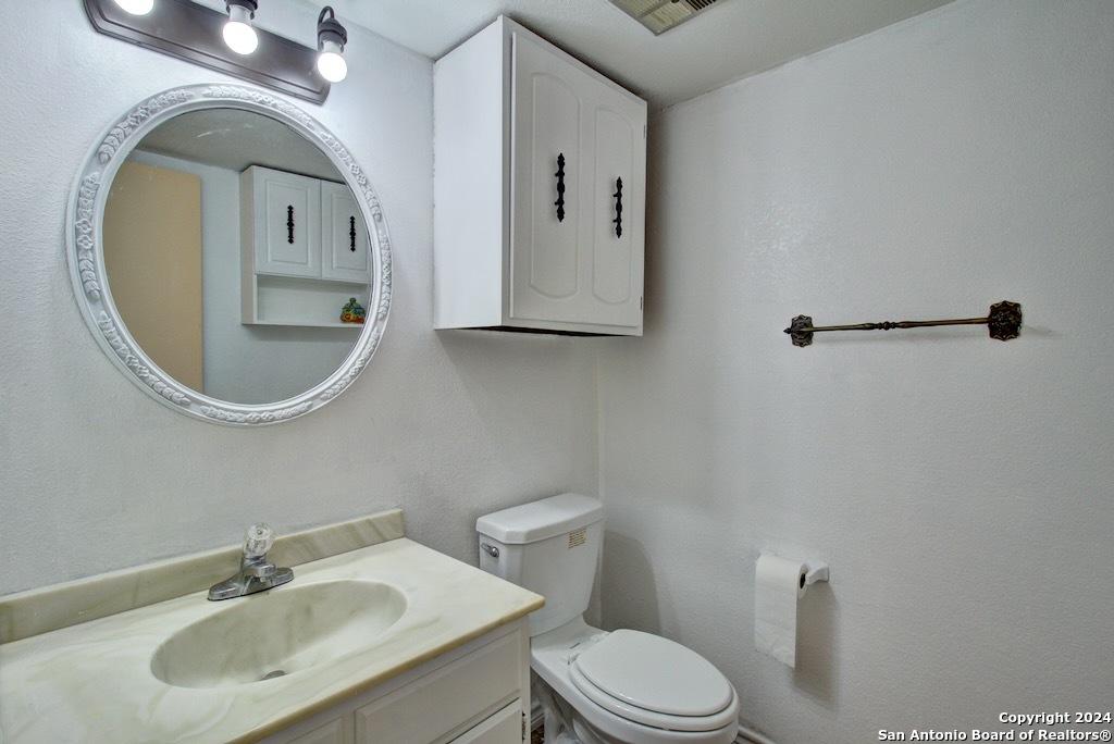 6810 Crown Ridge San Antonio, TX 78239 - Photo 24 of 34 a bathroom with a toilet sink and mirror