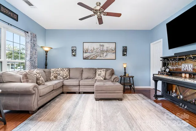 a living room with furniture a flat screen tv and a window