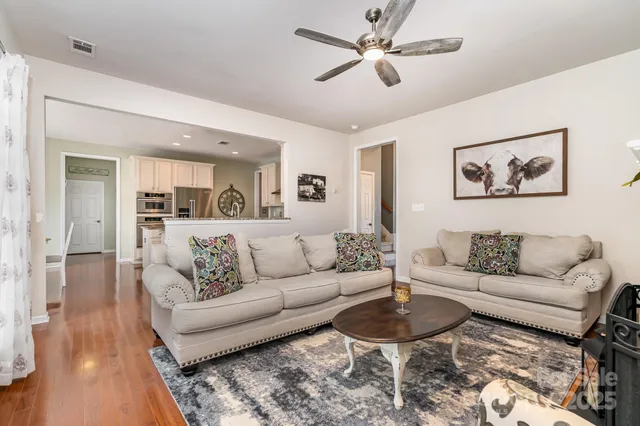 a living room with furniture and a view of kitchen