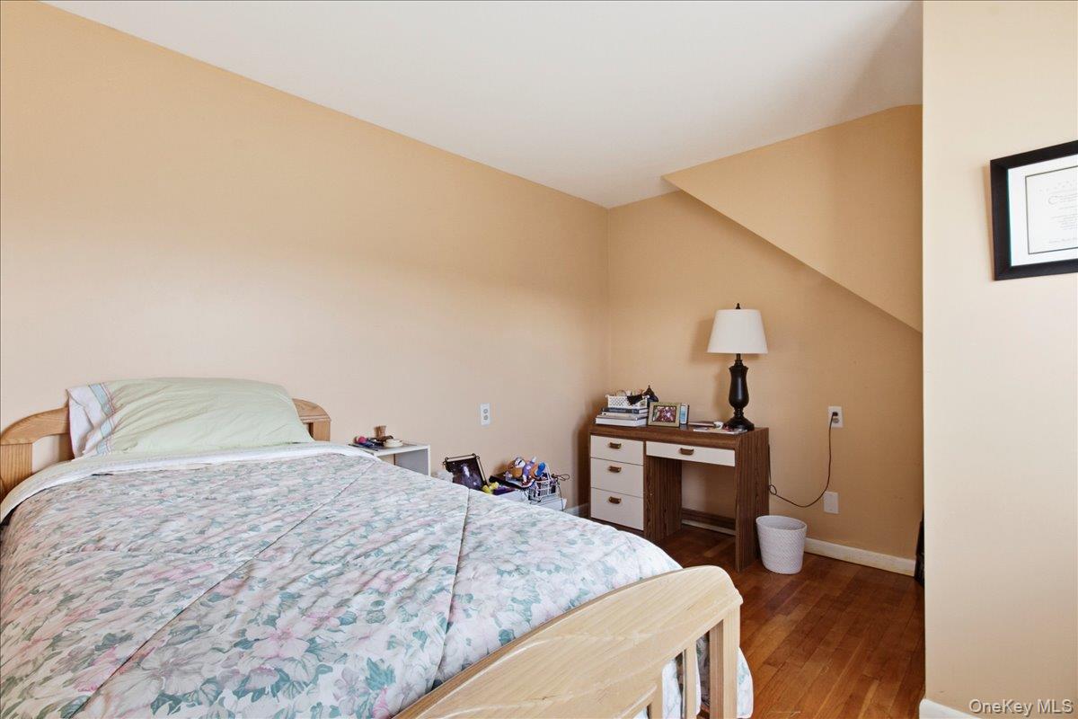 169 Canterbury Road White Plains, NY 10607 - Photo 11 of 27 a bedroom with a bed and a stove with wooden floor